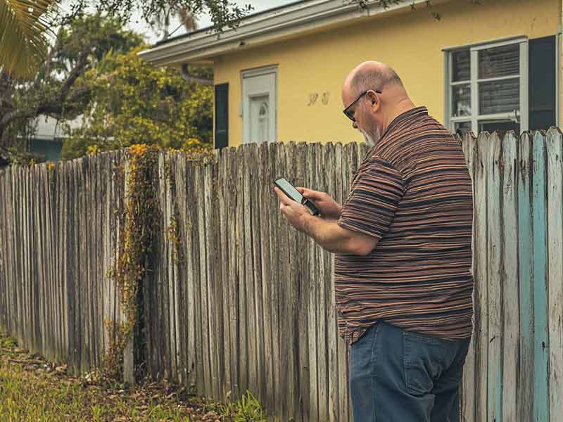 A man looks to rent a pressure washer from ToolBevy to clean his fence.